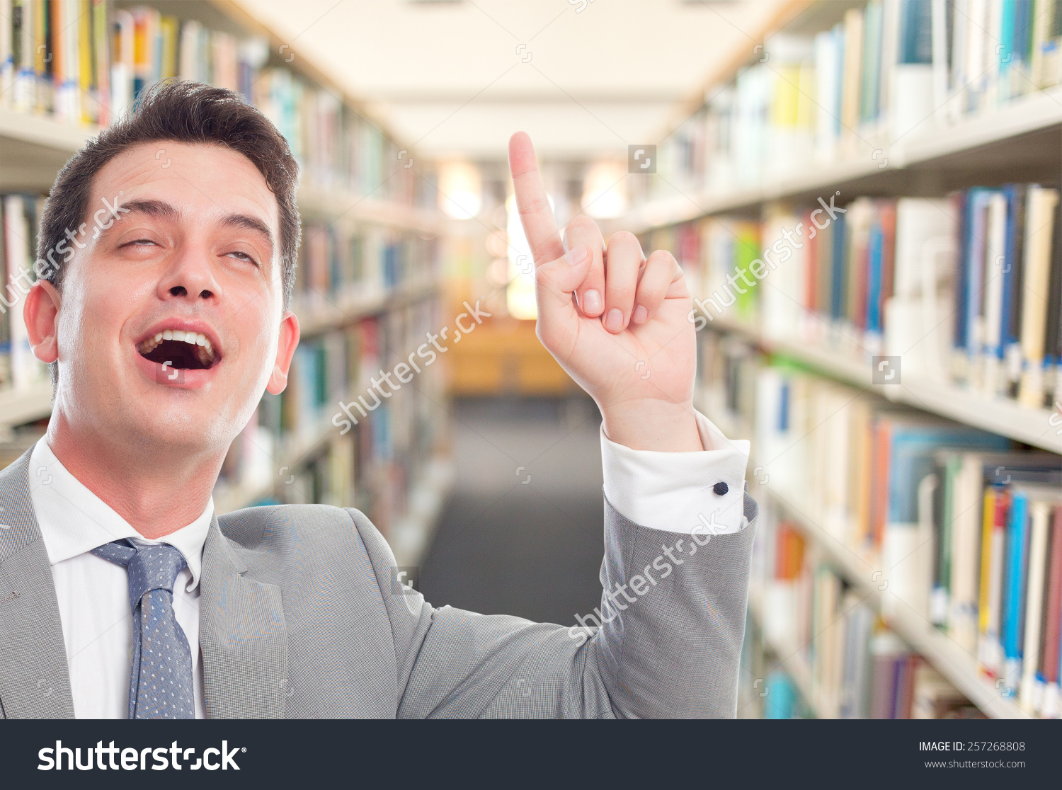 stock-photo-business-man-with-grey-suit-he-is-looking-funny-over-library-background-257268808